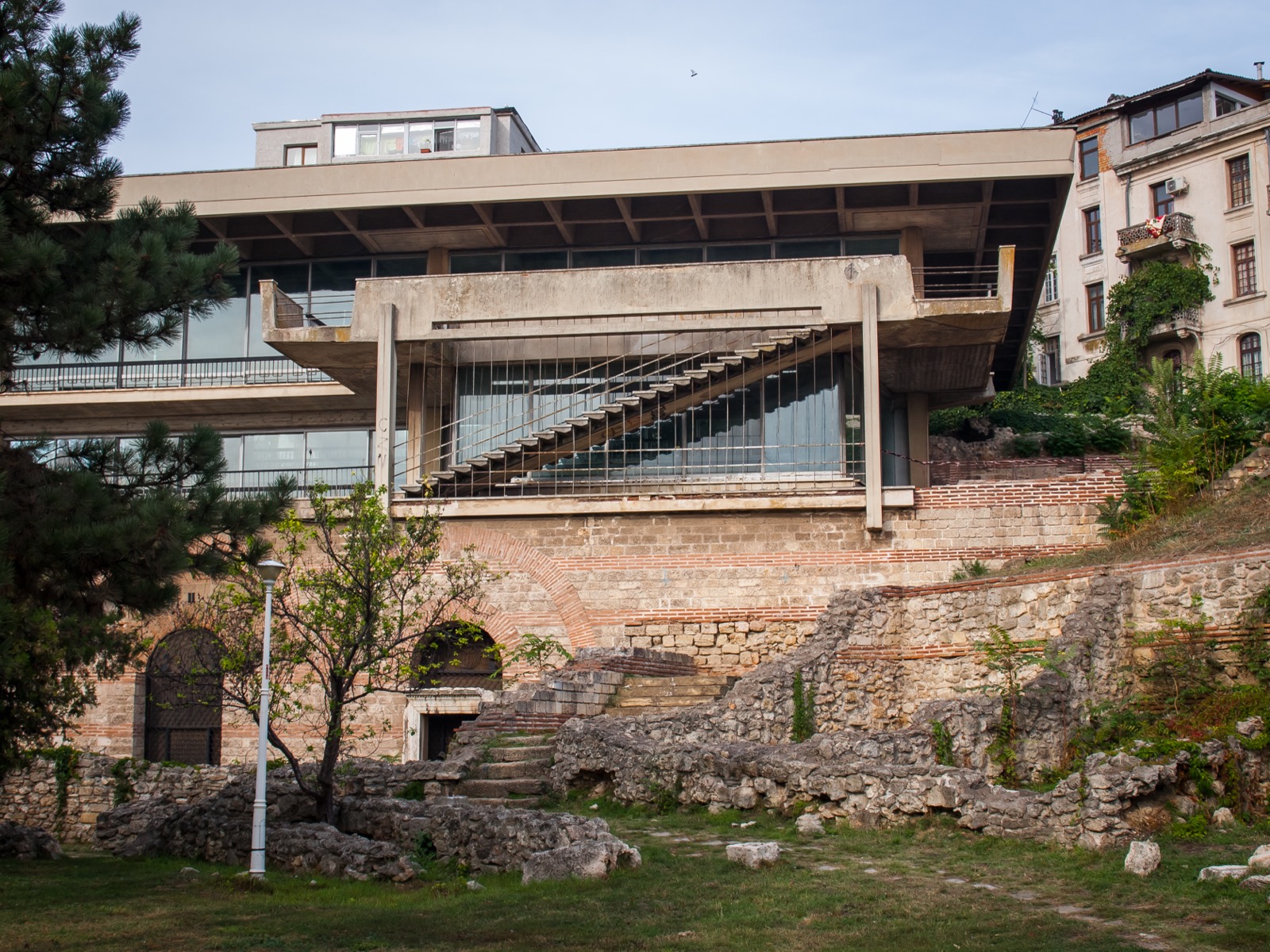 Clădirea de protecție a edificiului roman, deasupra zidurilor antice de pe terasele falezei