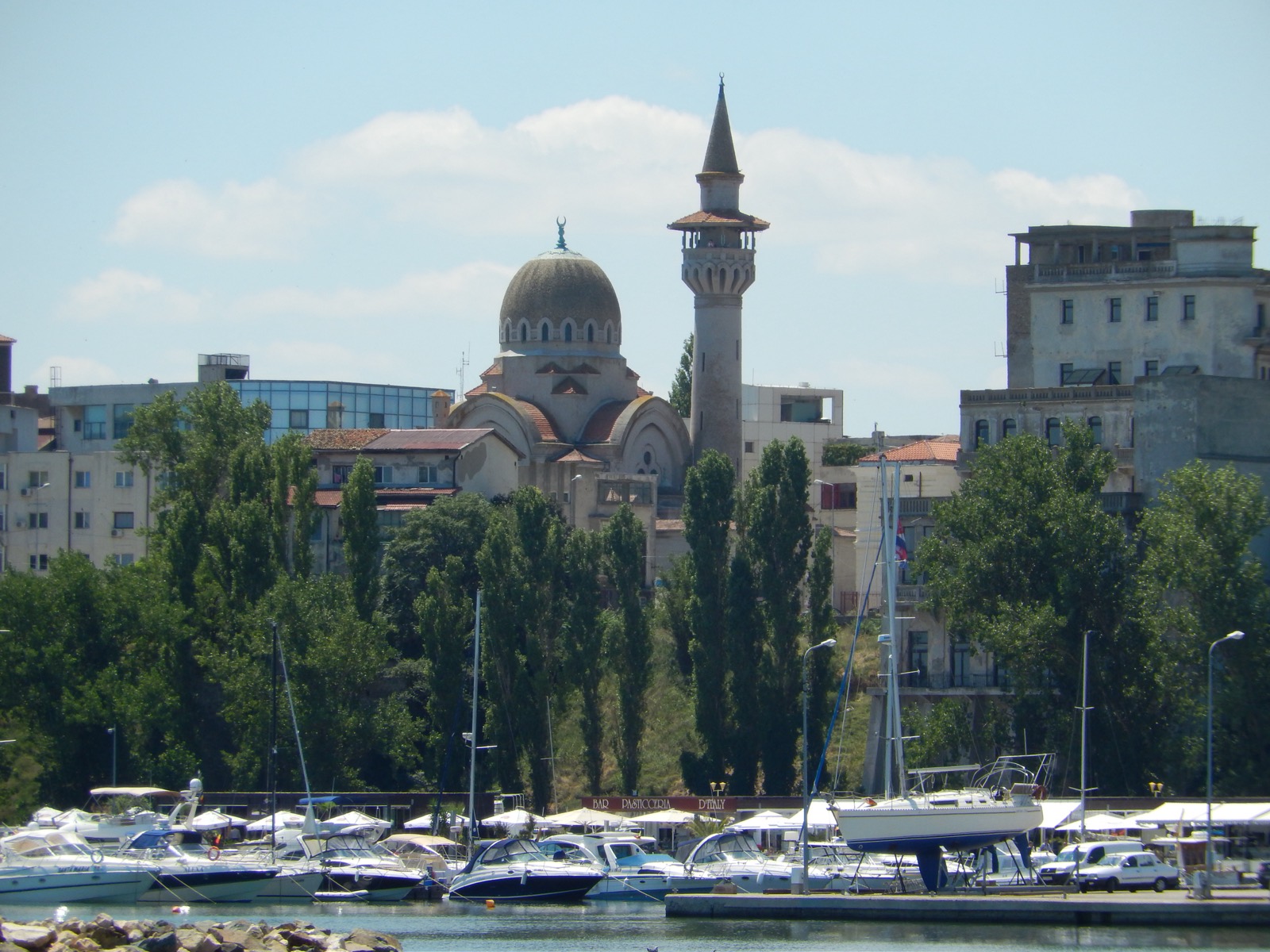 Cupola și minaretul moscheii deasupra copacilor din peninsulă, văzute dinspre portul turistic cu iahturi